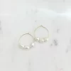 Two 30mm hoop earrings with gold plating and three white pearls on each earring placed side by side on a marble surface