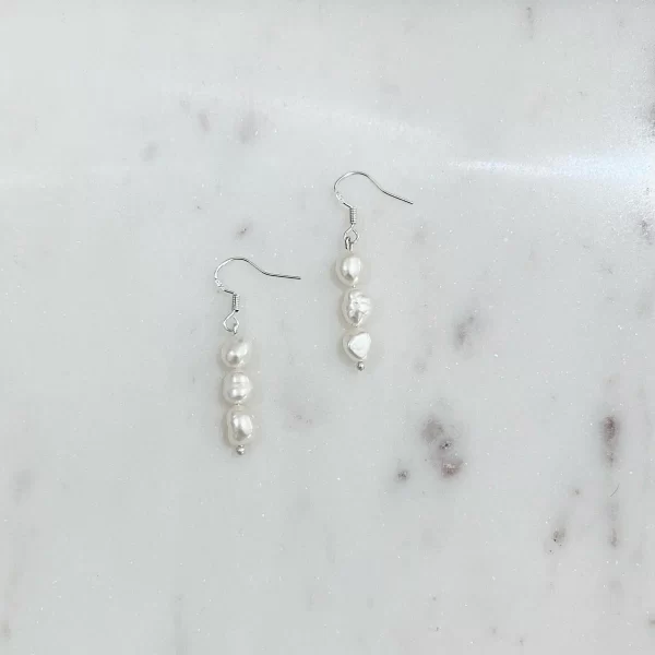 Lydia Pearl Earrings placed side by side on a marble surface
